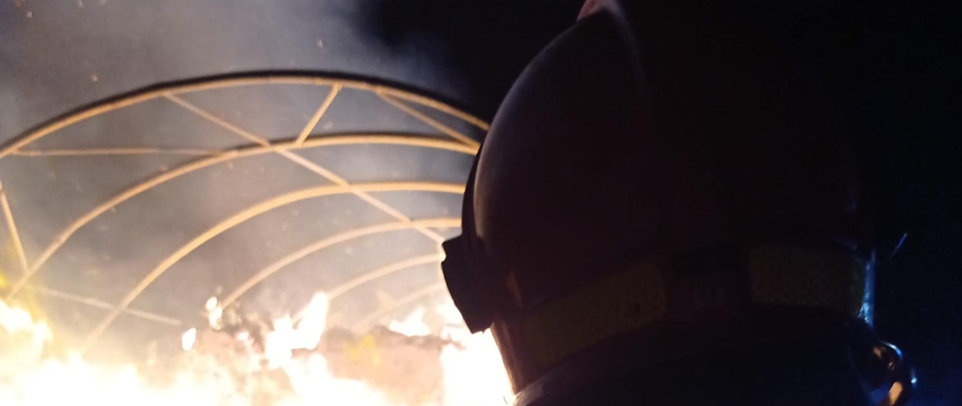 Strażak gasi palące się balot siana 