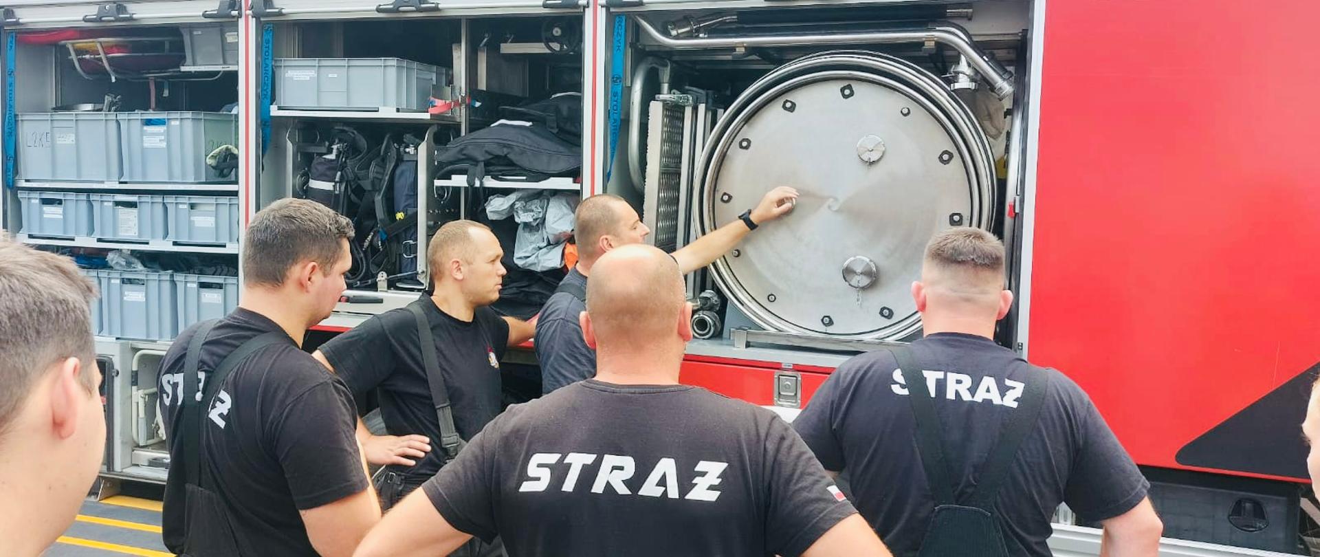 Strażacy na zajęciach praktycznych przy pojeździe specjalnym do ratownictwa chemicznego.