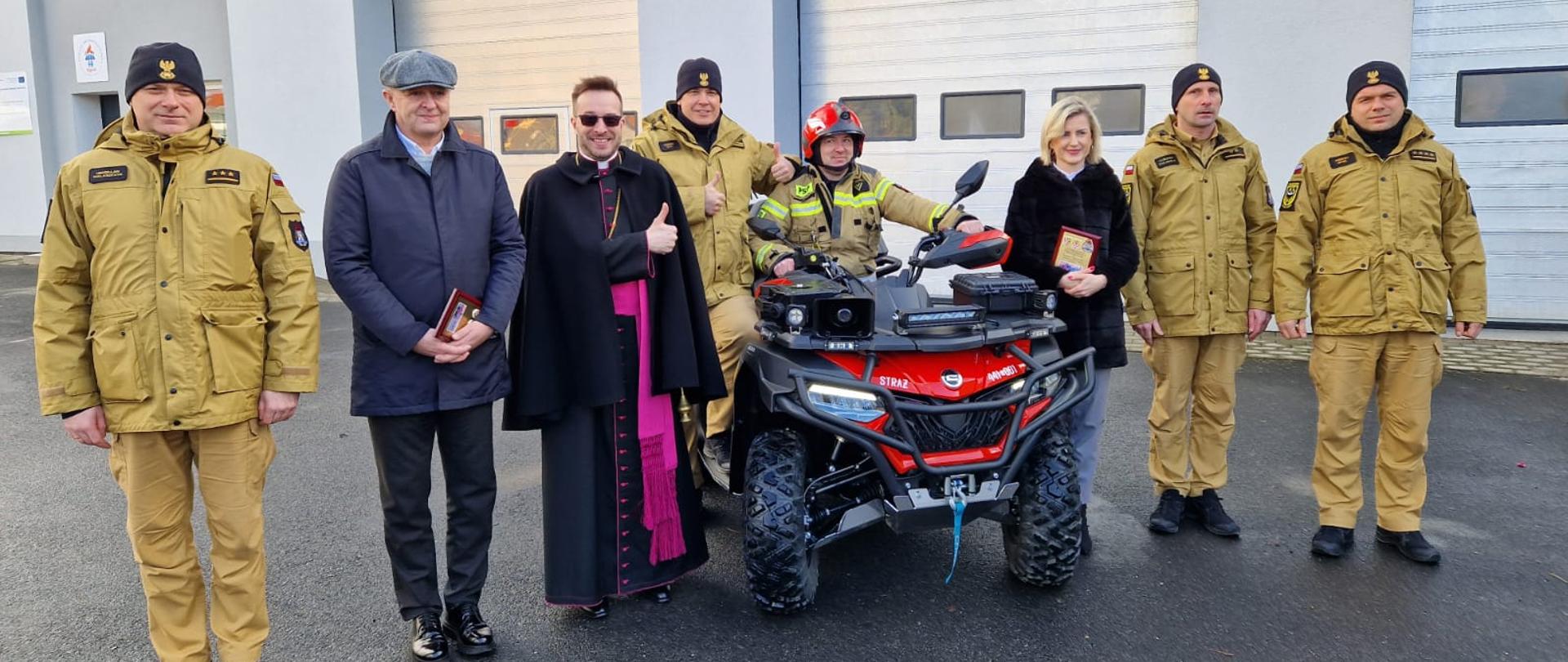 Wspólne zdjęcie z okazji przekazanie quada. W tel budynek garażowy. pora dzienna