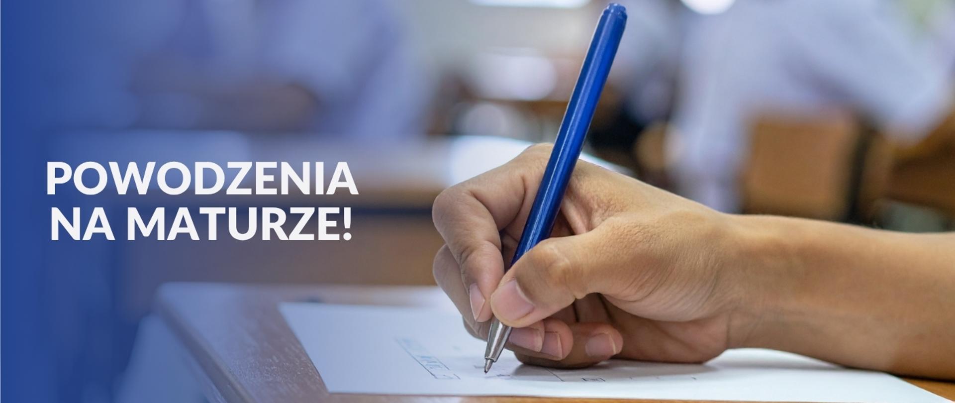 Grafika z tekstem po lewej stronie. Powodzenia na Maturze. Po prawej widok z boku na rękę z długopisem. 
