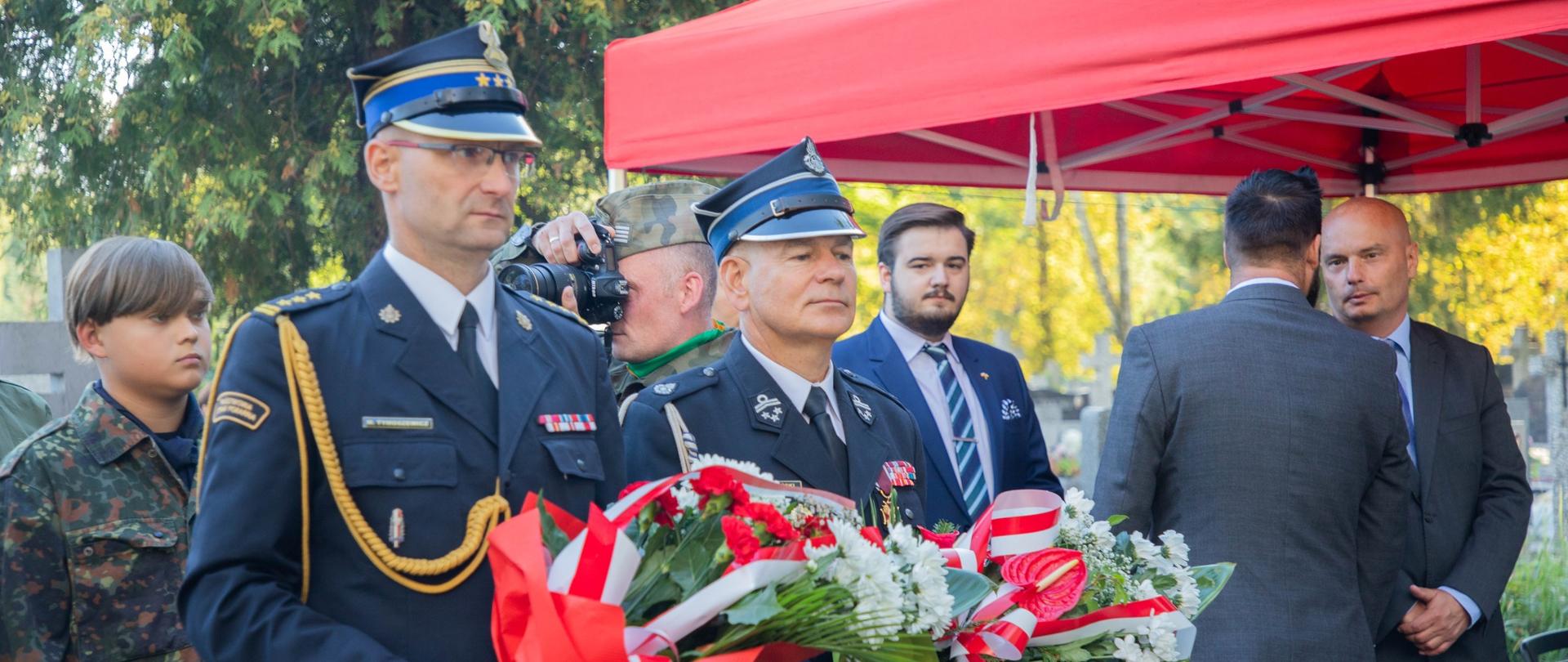 Komendant powiatowy PSP w Żyrardowie st. bryg. Mariusz Tymoszewicz wraz z byłym komendantem powiatowym PSP st. bryg. w st. spocz. Andrzejem Oklesińskim niosą wiązanki w celu ich złożenia pod pomnikiem.