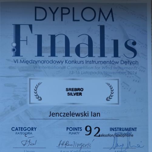 Dyplom w kolorze niebieskim. W nagłówku jest umieszczona nazwa konkursu, poniżej punktacja oraz podpisy jurorów.