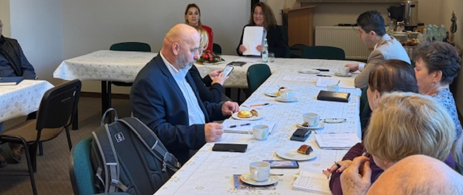 Grupa osób siedząca przy stołach