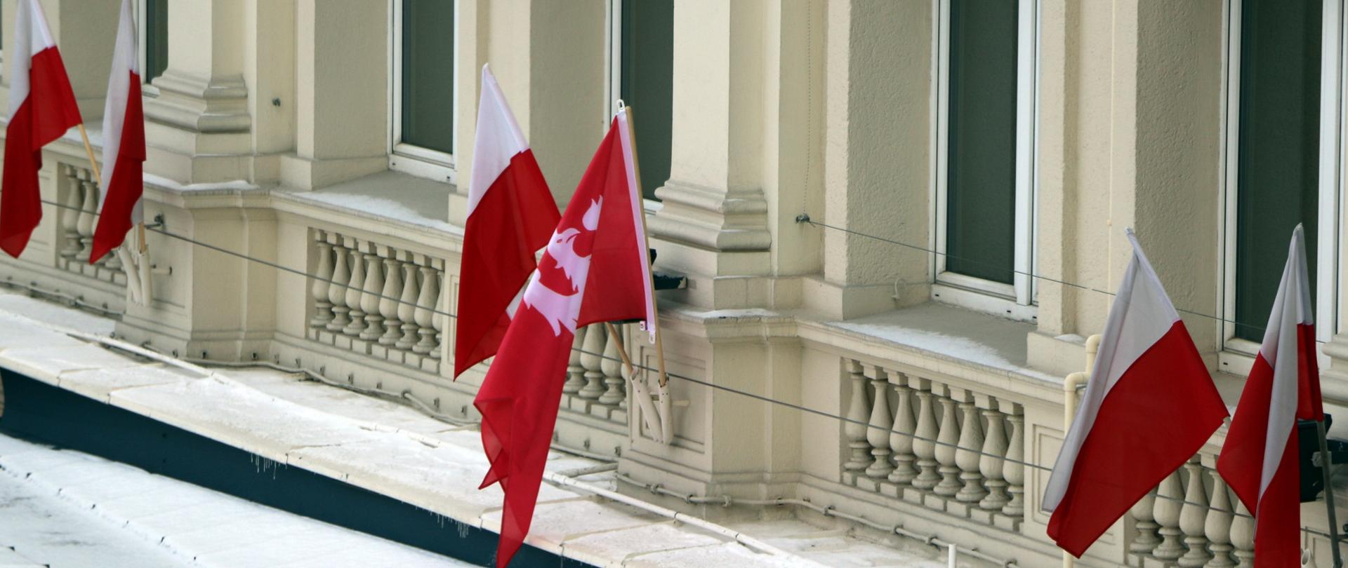 Flagi Polski oraz flaga powstania wielkopolskiego przedstawiająca orła w koronie na czerwonym tle znajdujące się na budynku Podkarpackiego Urzędu Wojewódzkiego w Rzeszowie