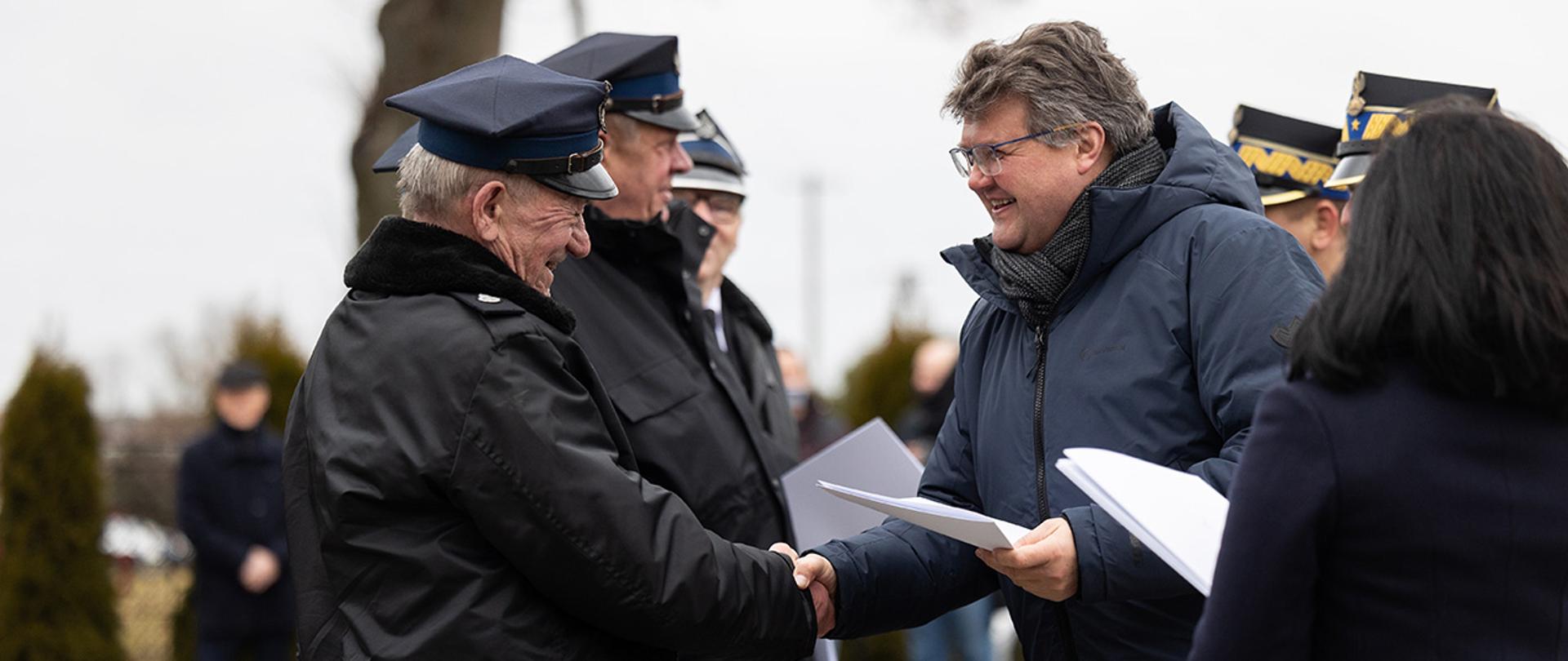 Na zdjęciu widać wiceministra Macieja Wąsika wręczającego jedną z decyzji.
