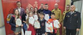 Zdjęcie zbiorcze laureatów turnieju z organizatorami. W tle ścianka PSP.