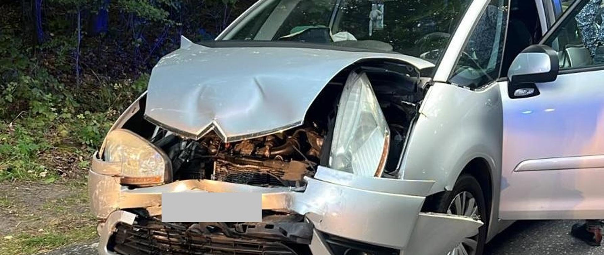 Samochód z mocno uszkodzonym przodem na drodze