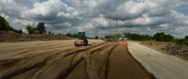 DK42 budowa obwodnicy Wąchocka - roboty ziemne na ciągu głównym trasy z użyciem walca i spycharki 