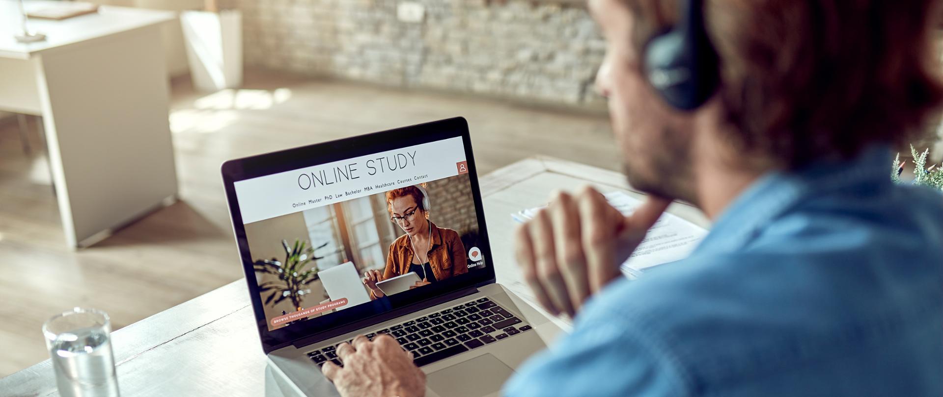Unrecognizable man using computer while e-learning from the office.