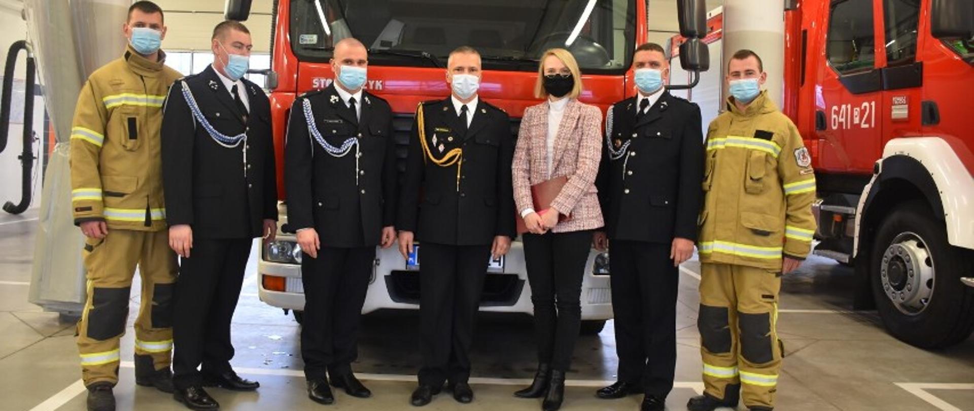 Zaproszeni goście stoją przy nowym pojazdem ratowniczo-gaśniczym