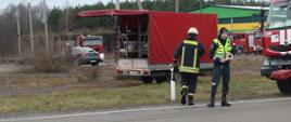 Strażacy litewscy na tle pojazdów ratowniczych