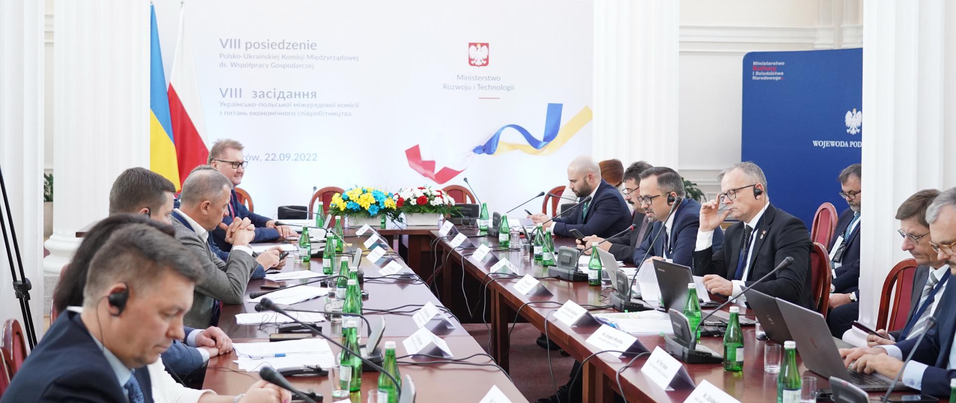  Wiceminister Puda siedzi w środku przy długim stole po prawej stronie.