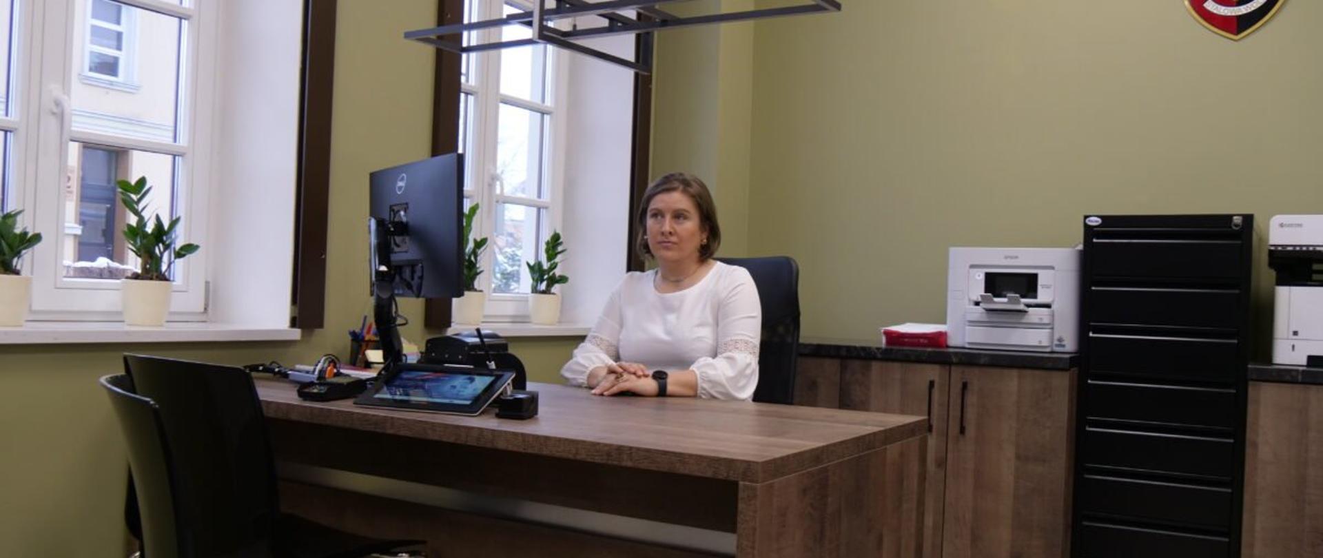 Kobieta siedząca przy biurku w punkcie paszportowym w Stalowej Woli