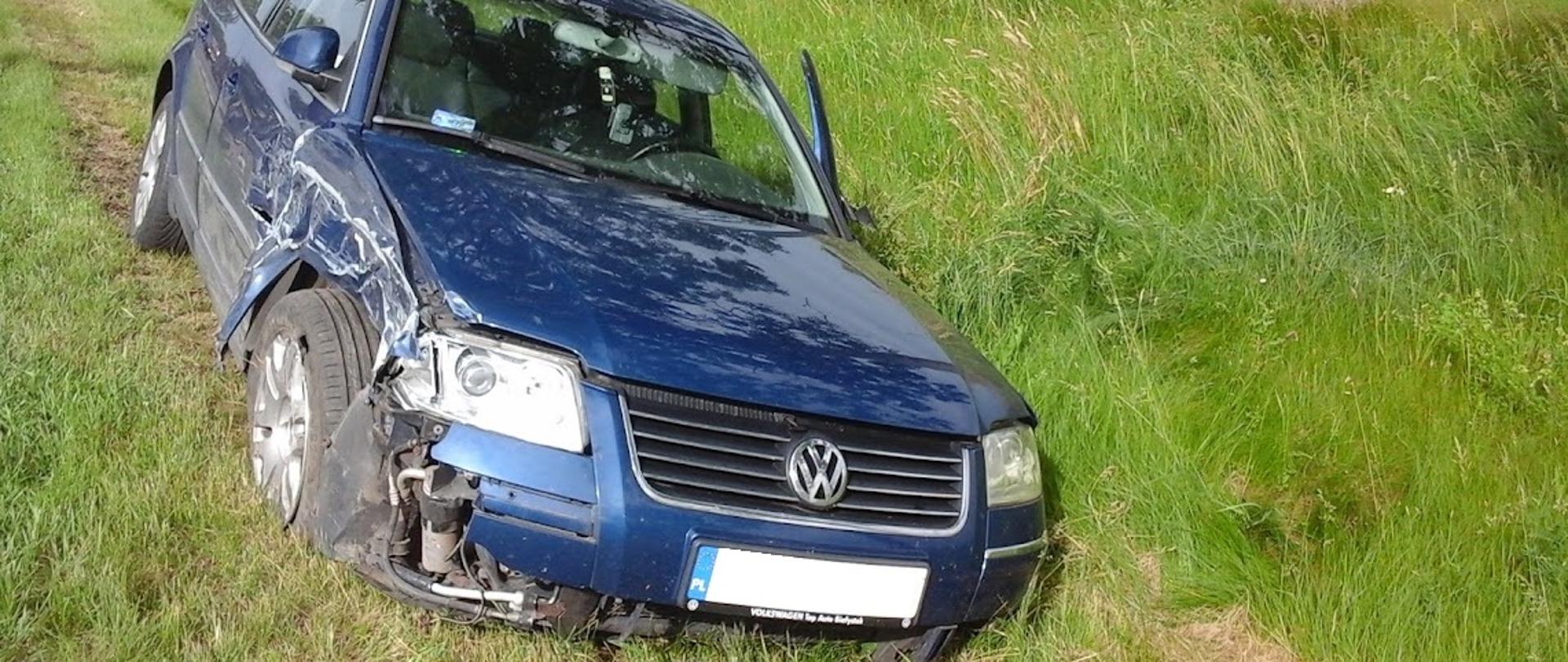 Samochód osobowy marki Volkswagen stojący po zderzeniu z innym pojazdem w rowie. Auto ma uszkodzone przednie lewe nadkole oraz drzwi.