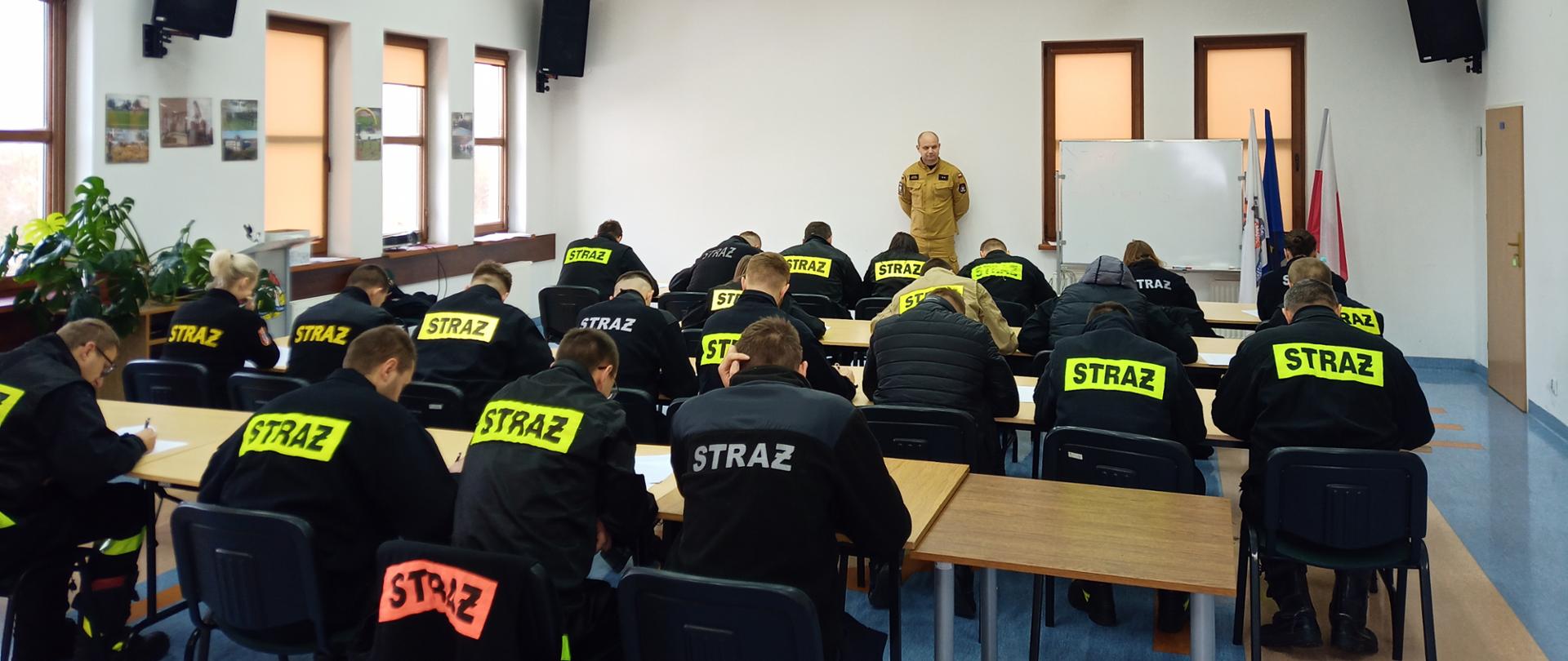 Egzamin potwierdzający posiadanie tytułu ratownika dla strażaków ratowników OSP 2023 - w sali szkoleniowej komendy trwa egzamin pisemny