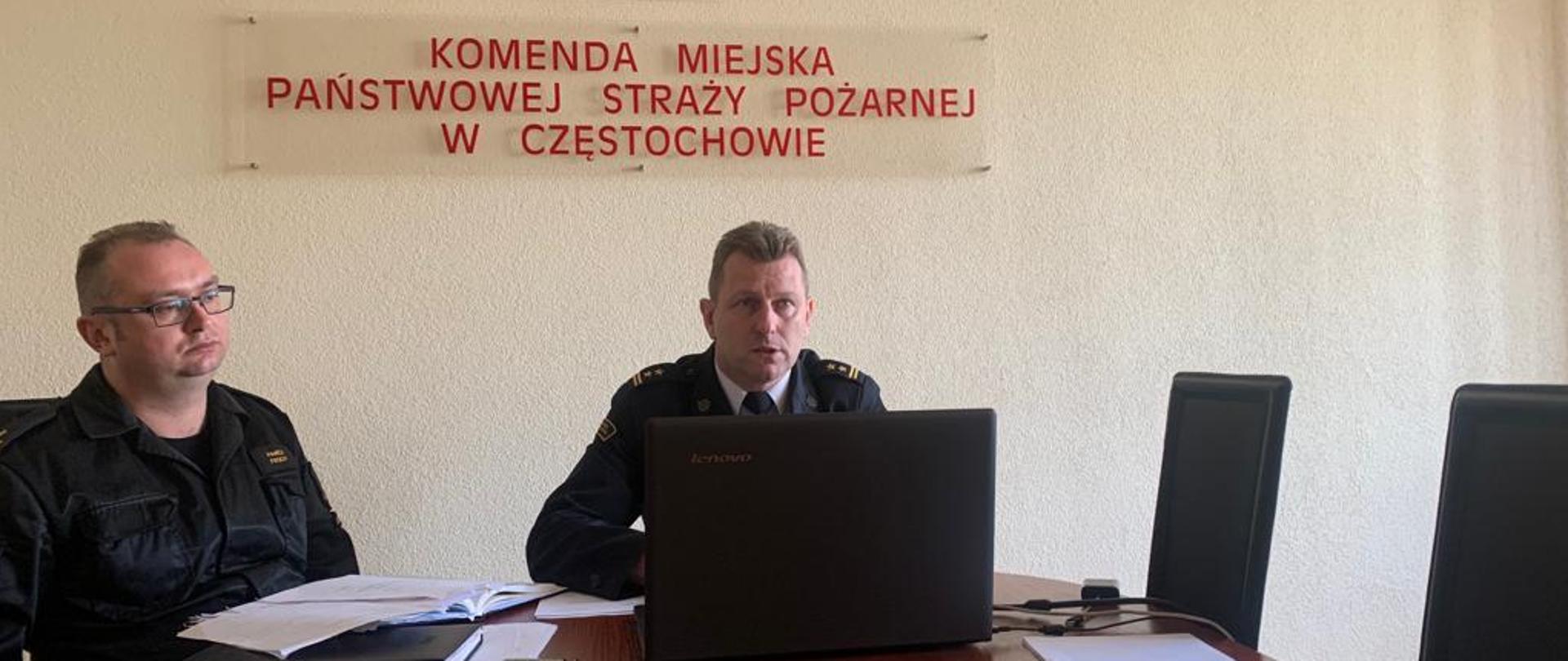 Na zdjęciu znajduje się Komendant Miejski Państwowej Straży Pożarnej w Częstochowie oraz Zastępca Komendanta Miejskiego Państwowej Straży Pożarnej w Częstochowie podczas odprawy w formie wideokonferencji z przedstawicielami jednostek samorządu terytorialnego, dotyczącej ustawy o OSP.