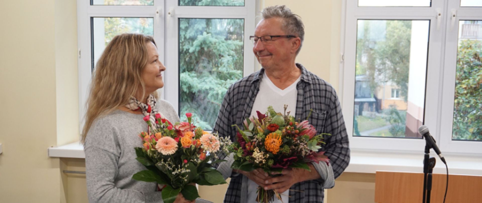 zdjęcie: Feliks Parnell Jr wraz z żoną Lindą Miller z bukietami kwiatów podczas spotkania z uczniami łódzkiej szkoły baletowej