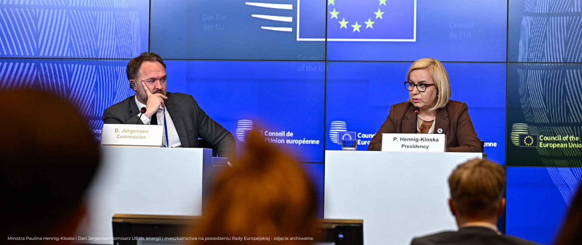 Na zdjęciu widać konferencję prasową, przy stołach prezydialnych siedzą dwie osoby – Dan Jørgensen komisarz UE ds. energii i mieszkalnictwa oraz Paulina Hennig-Kloska, minister klimatu i środowiska. W tle znajduje się ekran z symbolem flagi Unii Europejskiej. 