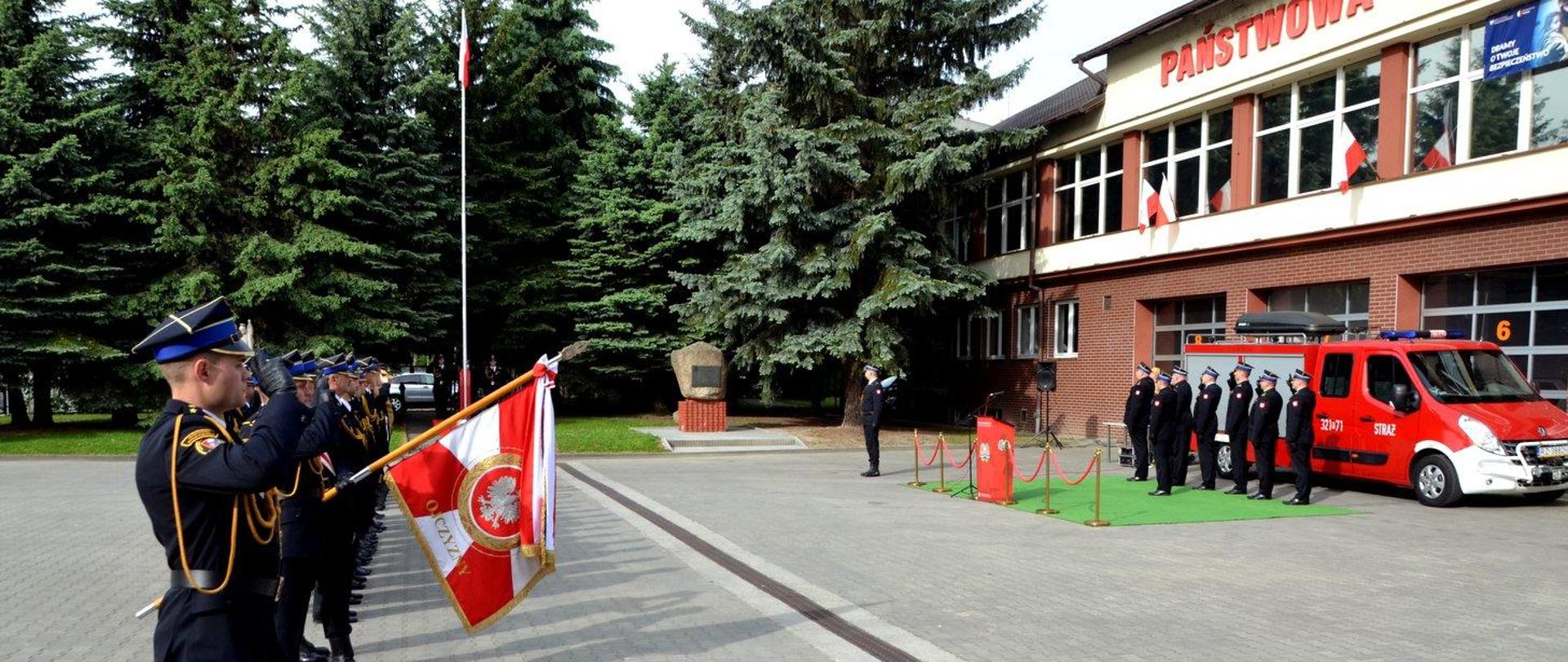 Zdjęcie zrobione na zewnątrz. W Komendach Miejskich i Powiatowych PSP woj. podkarpackiego odbyły się dziś uroczyste zbiórki, w czasie której podniesiono na maszt Flagę Rzeczypospolitej Polskiej.