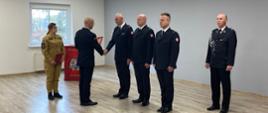 Komendant wręcza awans strażakowi podczas zbiórki