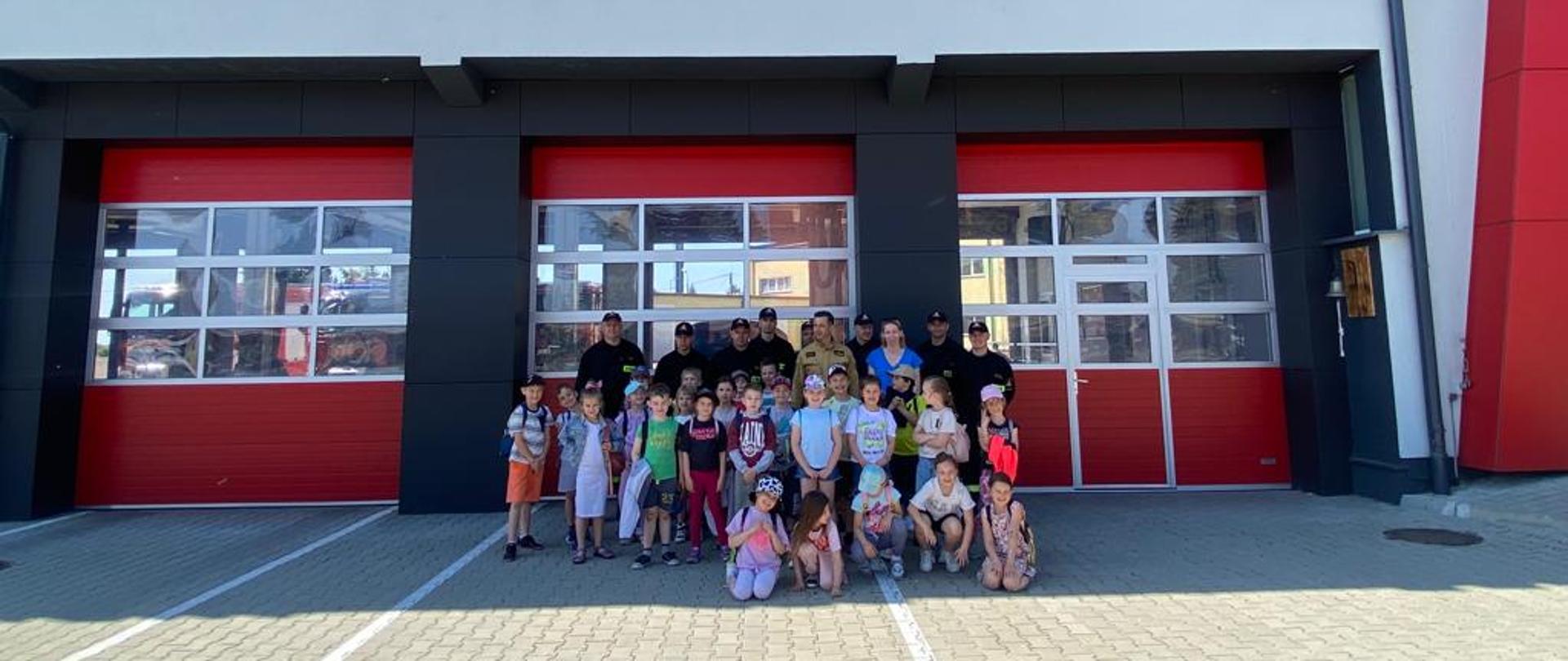 Zdjęcie dzieci i strażacy podczas wizyty w komendzie