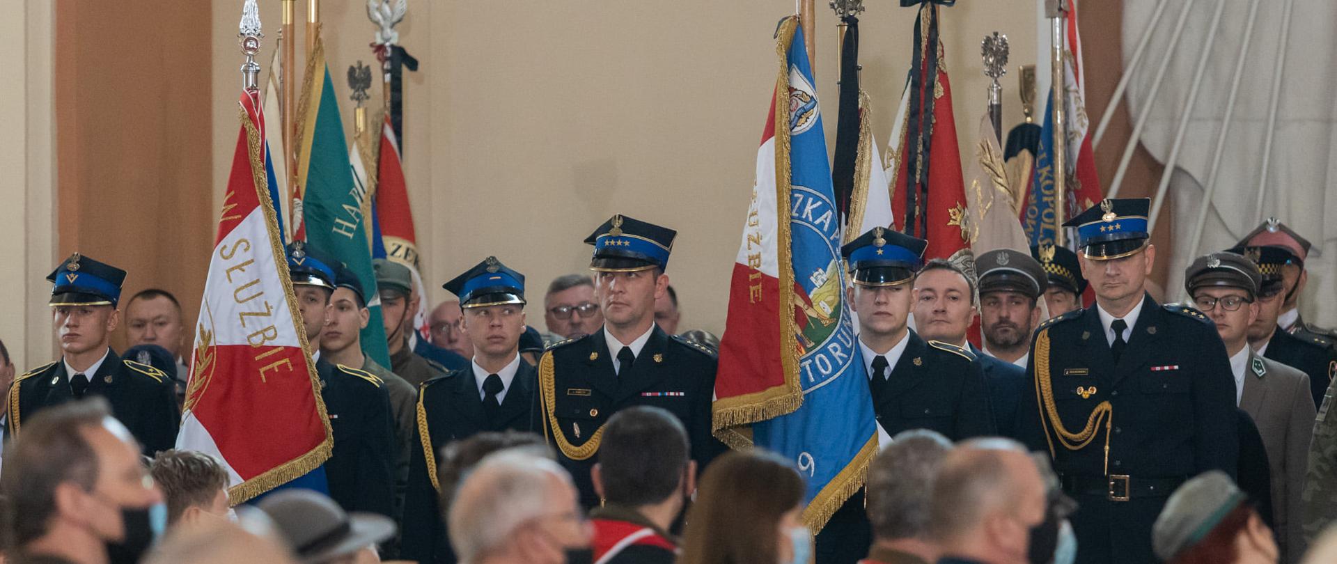 Na zdjęciu poczet sztandarowy Komendy Wojewódzkiej PSP w Toruniu oraz poczet sztandarowy Komendy Miejskiej Państwowej Straży Pożarnej w Bydgoszczy, funkcjonariusze ubrani w mundury wyjściowe PSP. W tle pozostałe poczty stojące wewnątrz Bazyliki