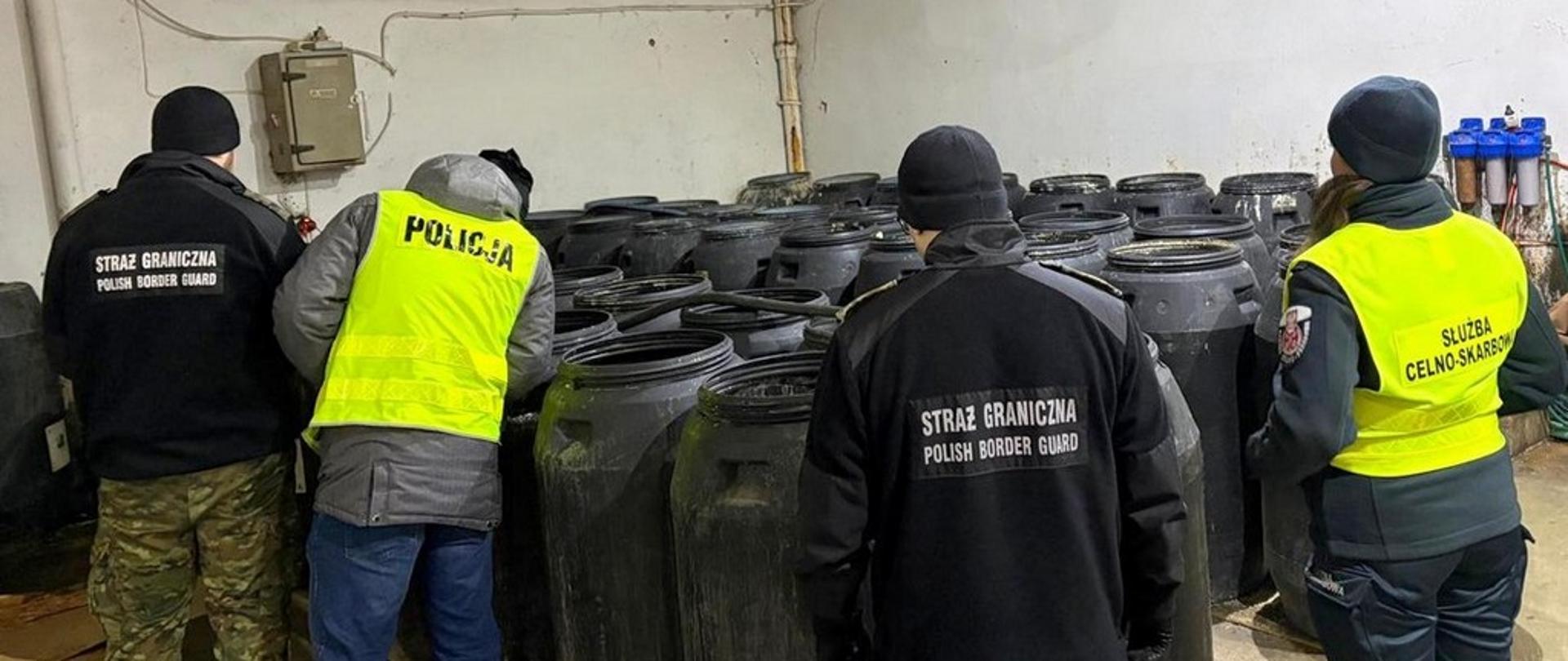 Funkcjonariusze we wnętrzu bimbrowni