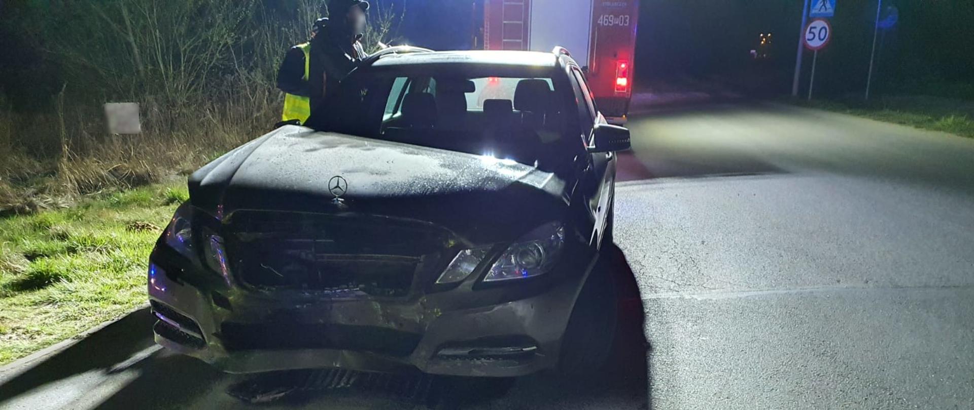 widoczne miejsce zdarzenia uszkodzony pojazd oraz strażacy działający na terenie