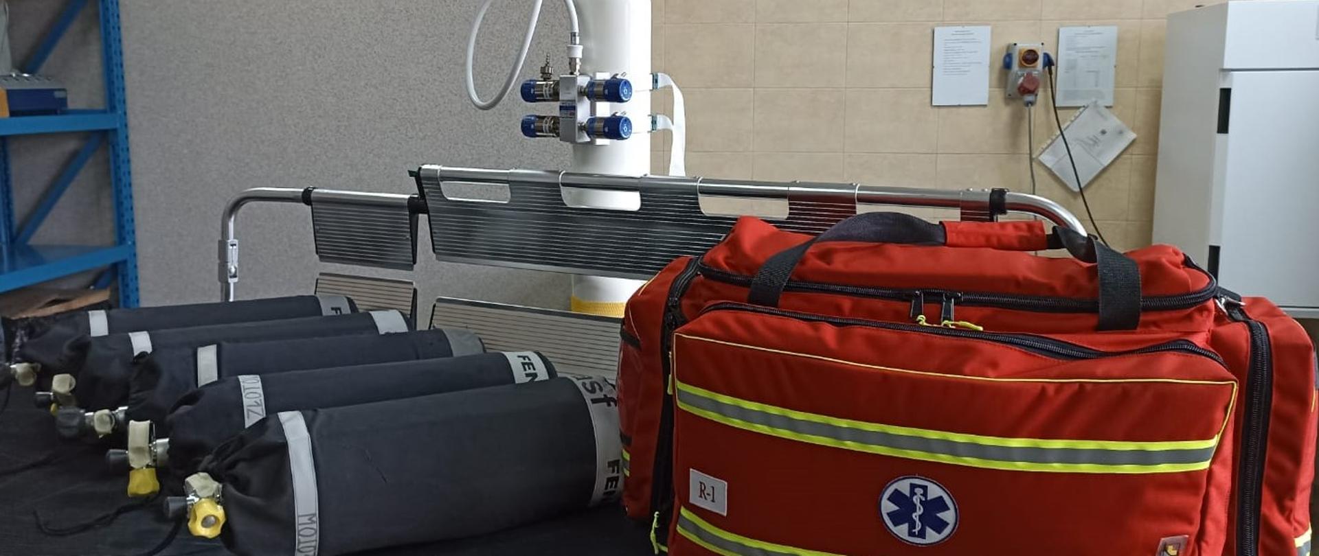 Na zdjęciu sprzęt medyczny torba PSP r-1 butla tlenowa oraz butle z powietrzem.