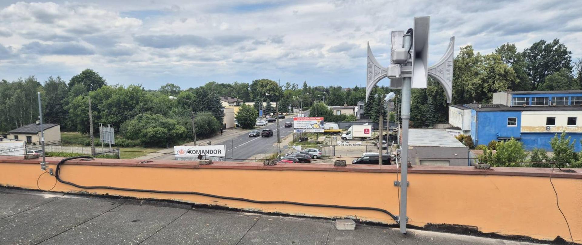 Zdjęcie przedstawia syrenę alarmową na dachu budynku.