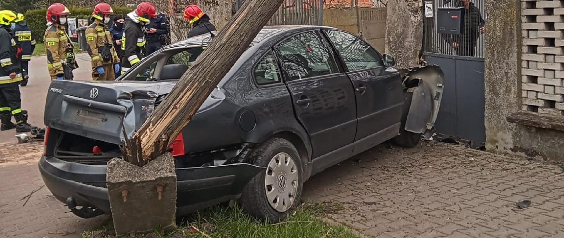 Na zdjęciu widoczny samochód osobowy (volkswagen passat), który uderzył w słup oraz bramę do posesji. 