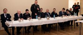 Widok z przodu na stół prezydialny. Głos zabiera małopolski komendant wojewódzki PSP nadbyg. Piotr Filipek.