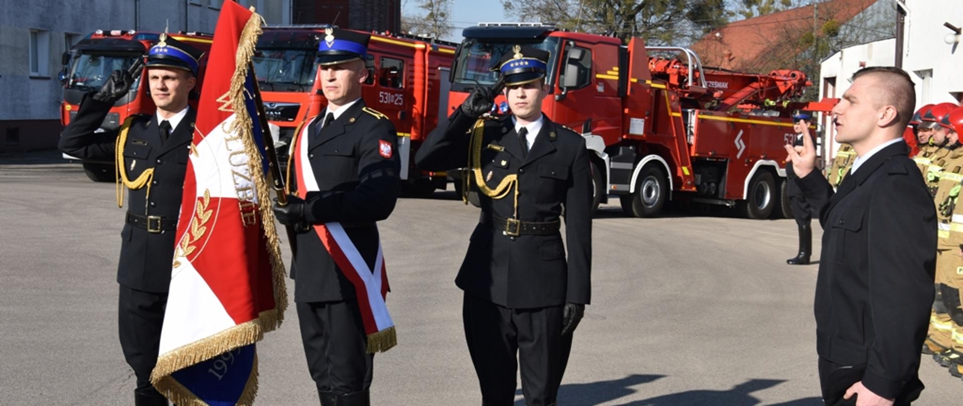 Strażak składa ślubowanie na sztandar.