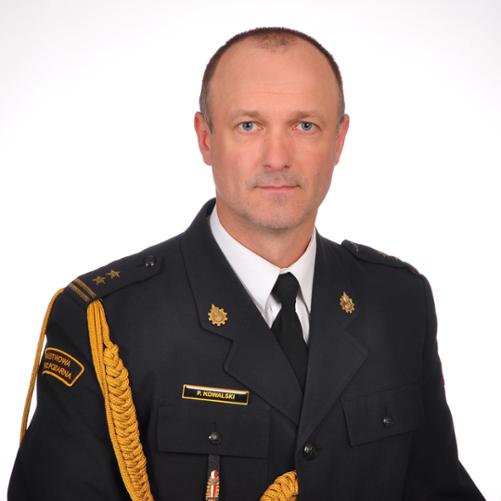 Zdjęcie portretowe bryg. mgr inż. Pawła Kowalskiego - Zastępcy Komendanta Powiatowego PSP w Kozienicach w mundurze wyjściowym na jasnym tle