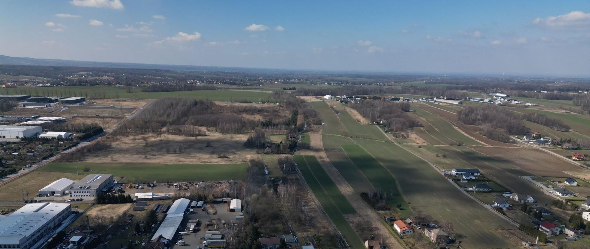 zdjęcie lotnicze północnej części Andrychowa, gdzie planowana jest budowa węzła Beskidzkiej Drogi Integracyjnej, w centrum pola i zadrzewienia, wokół rozproszona zabudowa