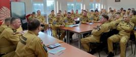 na zdjęciu w sali wykładowej widoczni strażacy w mundurach służbowych podczas narady rocznej wraz z komendantami oraz dowódcami JRG