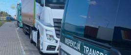 Oznakowany furgon mazowieckiej Inspekcji Transportu Drogowego i stojące za nim dwa zestawy ciężarowe.