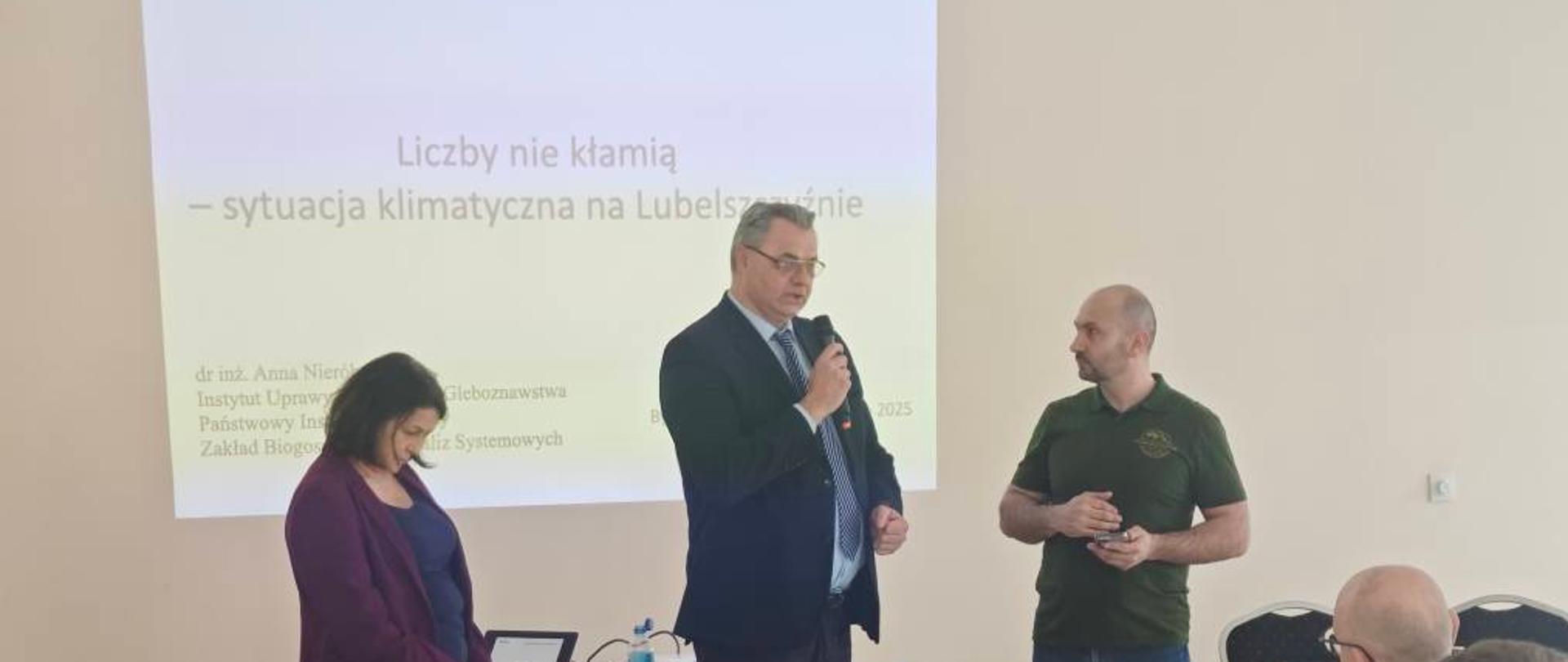Mężczyzna trzymający mikrofon przemawia do uczestników szkolenia