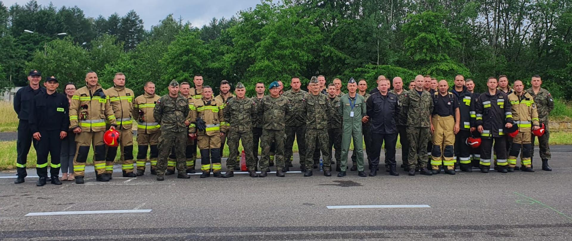 Zdjęcie przedstawia startujące jednostki w Zawodach Wojskowych Straży Pożarnych w 21. bazie lotnictwa Taktycznego w Świdwinie. Stoją wszyscy w dwu szeregu.