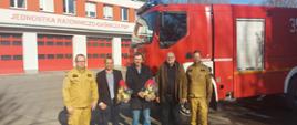 Na zdjęciu widać Zastępcę Komendanta Miejskiego Państwowej Straży Pożarnej w Częstochowie brygadiera Pawła Frocha wraz z przedstawicielami firmy Liberty Częstochowa Spółka z ograniczoną odpowiedzialnością Panem Jarosławem Huptysiem, Panem Jackiem Noszczykiem i Panem Robertem Gonerą oraz Zastępcą Dowódcy Jednostki Ratowniczo-Gaśniczej numer 1 w Częstochowie młodszym brygadierem Krzysztofem Dzwonnikiem, stojących na tle budynku Jednostki i ciężkiego samochodu ratowniczo-gaśniczego.