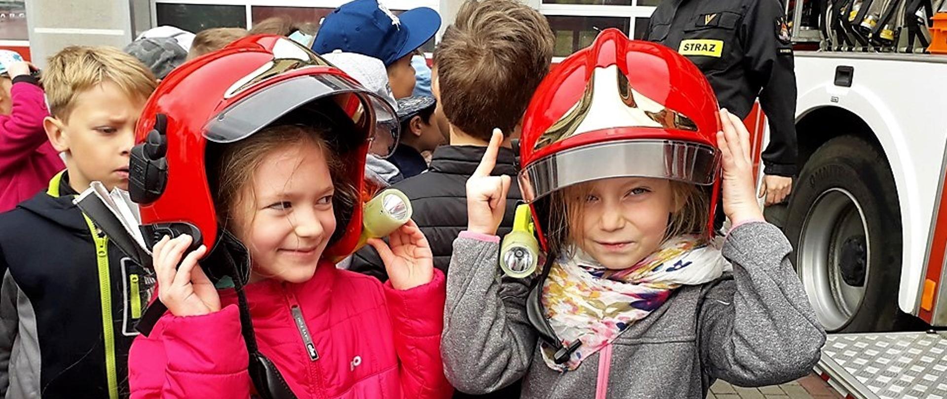 Dwie dziewczynki w hełmach strażackich