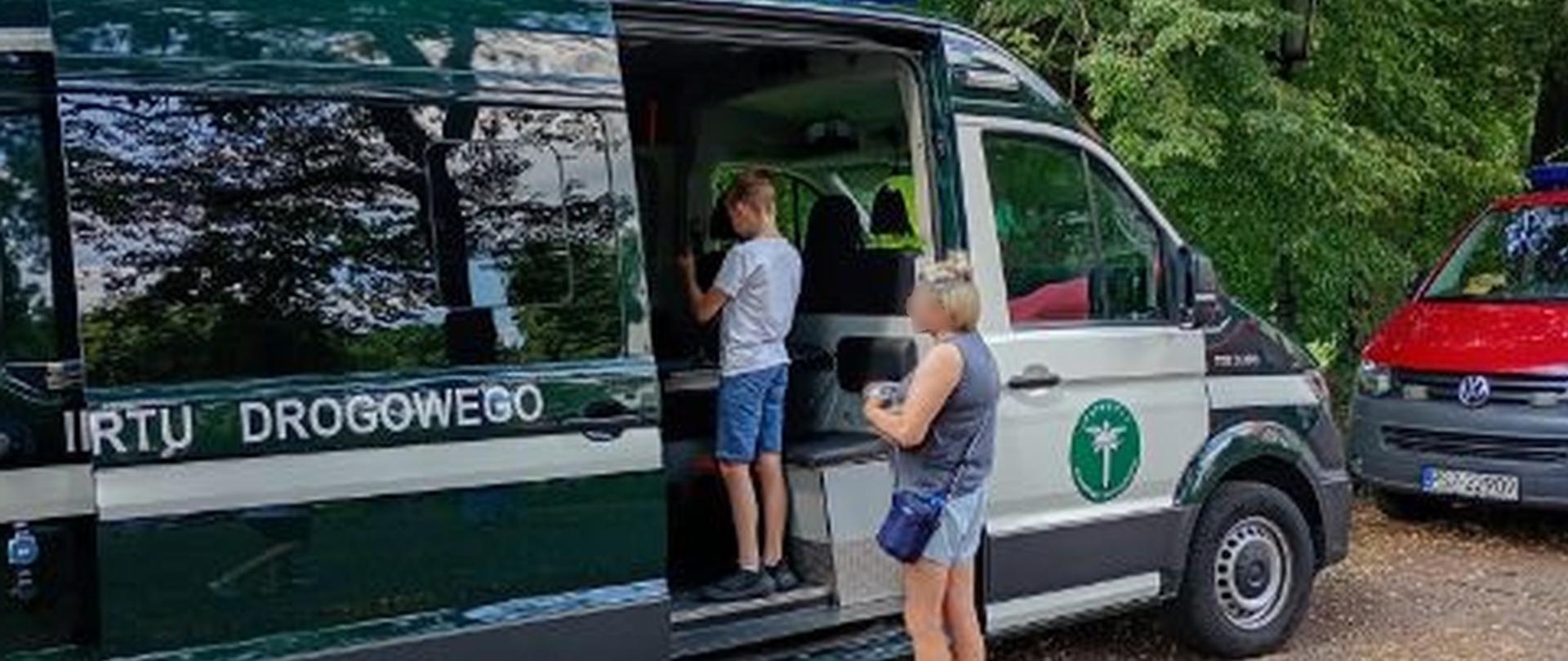 Kobieta z dzieckiem oglądają pojazd WITD.