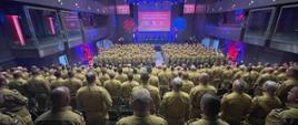 Na sali konferencyjnej kilkuset funkcjonariuszy podczas odprawy. Wszyscy tyłem, przodem do ekranu.