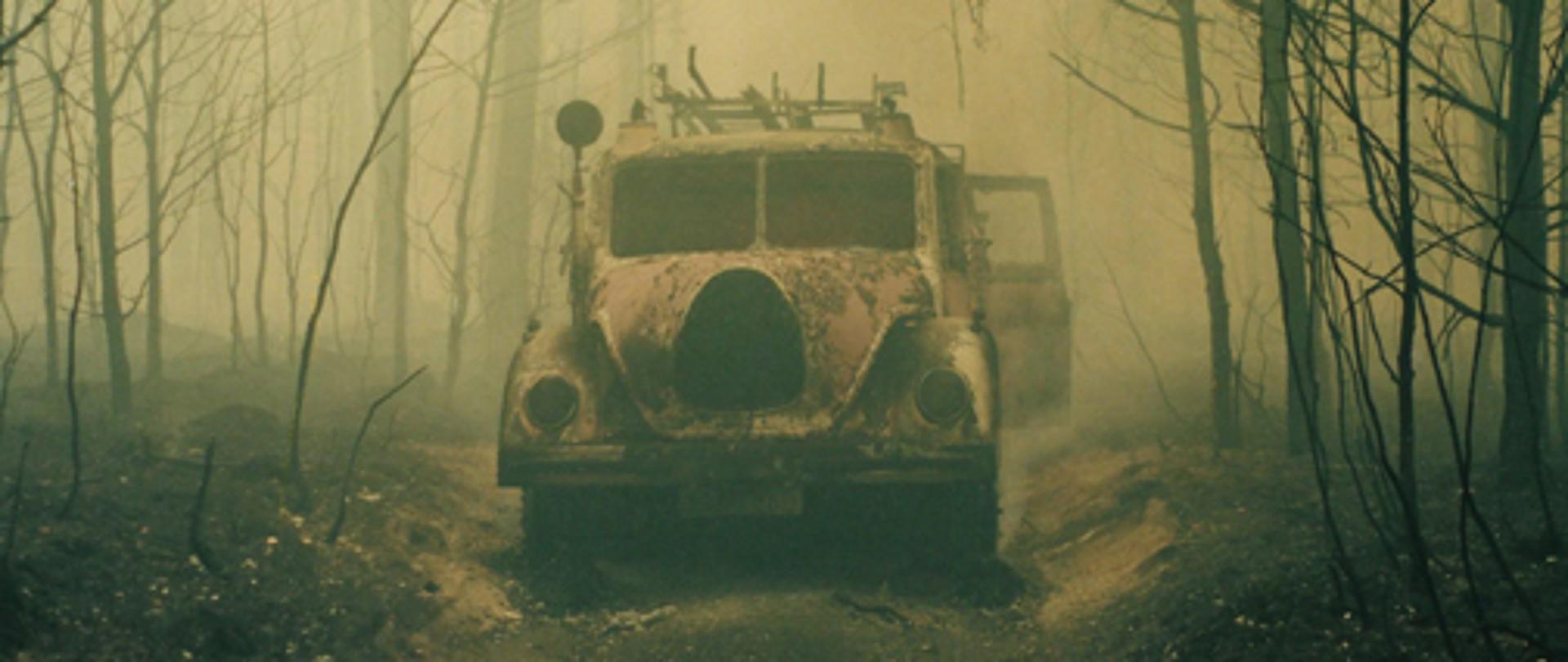 Spalony samochód strażacki na leśnej drodze