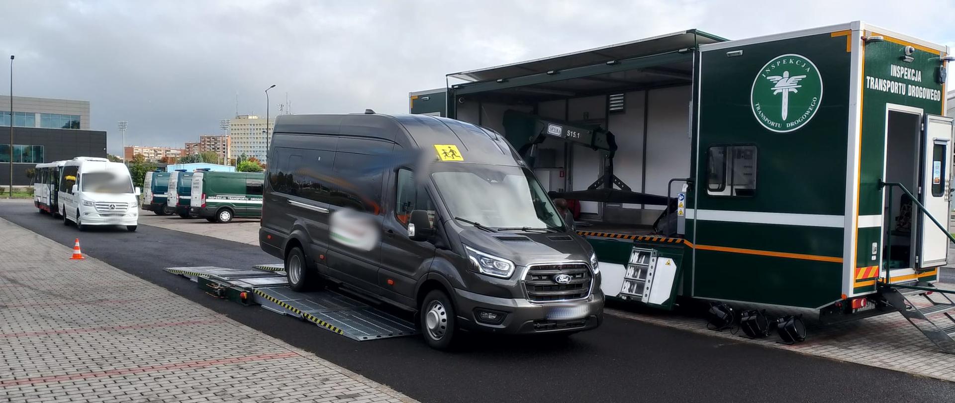 Bus osobowy stojący na platformie do badania stanu technicznego pojazdów. 