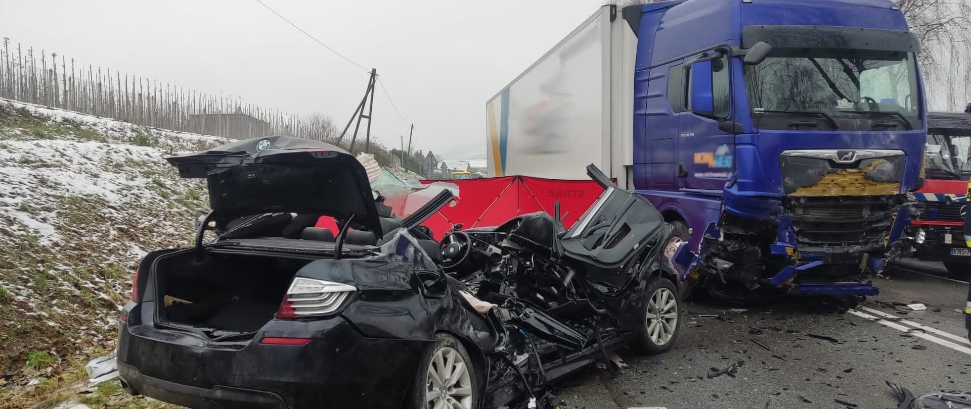 Rozbity samochód osobowy oraz ciężarowy na drodze.