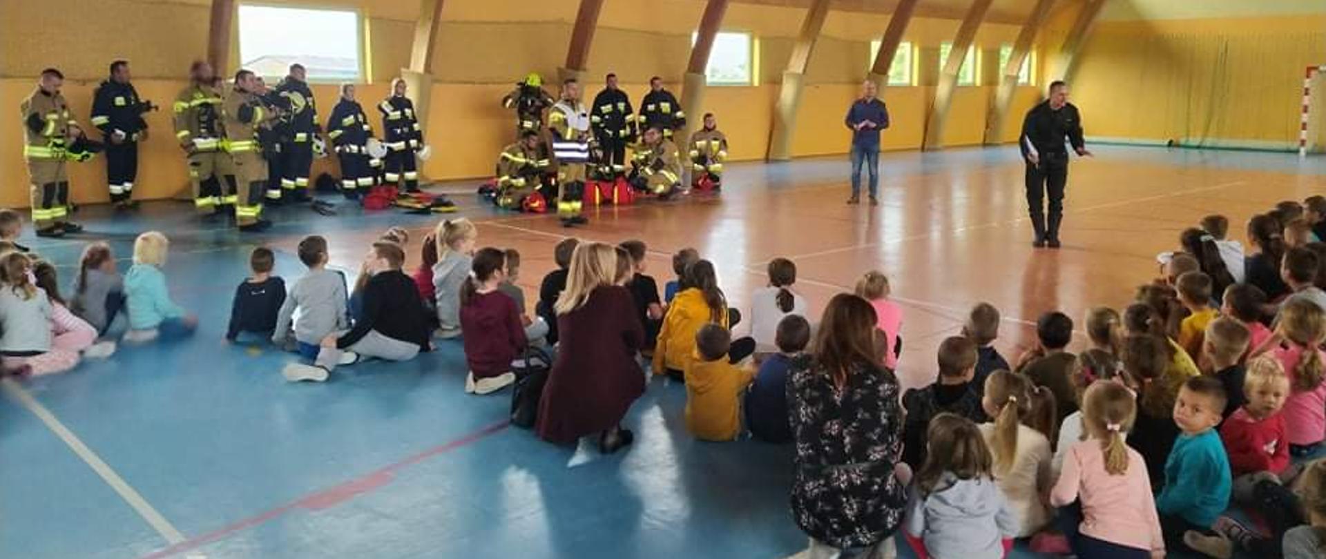 Uczniowie w trakcie pogadanki o zasad bezpiecznego zachowania prowadzonej przez przedstawiciela KP PSP Iława 
