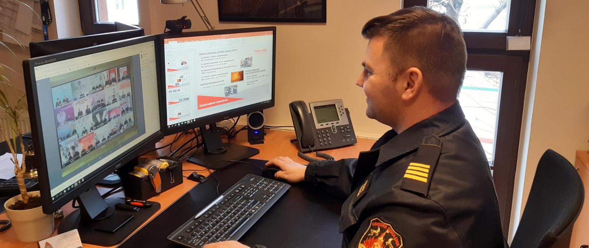 strażak siedzi przed komputerem