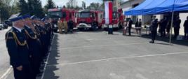Strażacy stojący na placu podczas obchodów Dnia Strażaka
