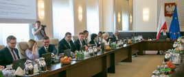 Zdjęcie przedstawia posiedzenie Rady Ministrów. Przy stole siedzą ministrowie (m.in. podsekretarz stanu w MGMiŻŚ Grzegorz Witkowski) oraz prezes rady ministrów.